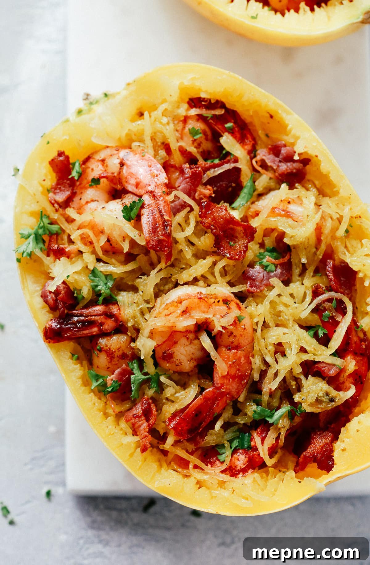 Keto Dinner Recipes: Low-Carb Ideas for Weeknights 16 Overhead view of spaghetti squash with shrimp and bacon on a marble board.