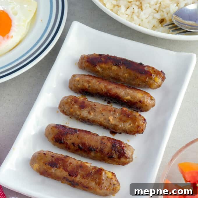 Skinless Longganisa on serving platter with plates of rice and fried eggs on the side