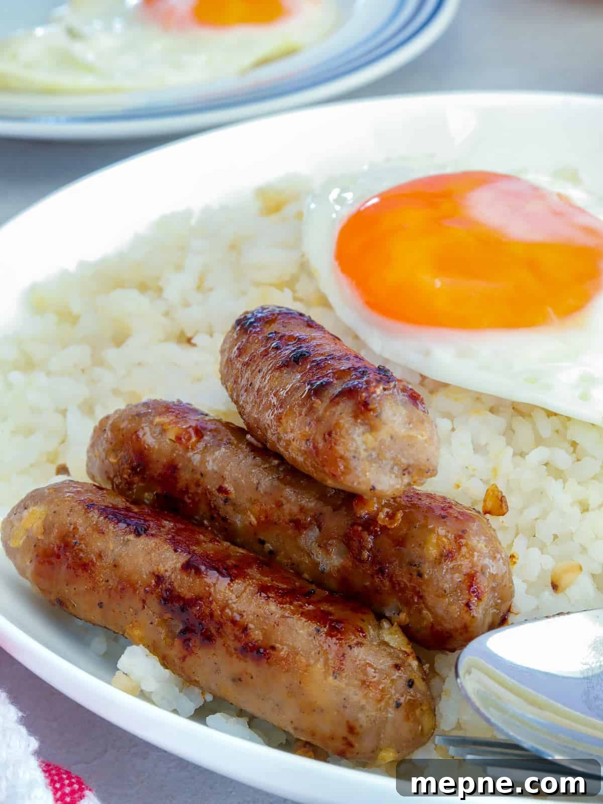 Filipino Skinless Longganisa Recipe for Homemade Sausage 7 Skinless Longganisa on a serving plate with fried eggs and garlic fried rice
