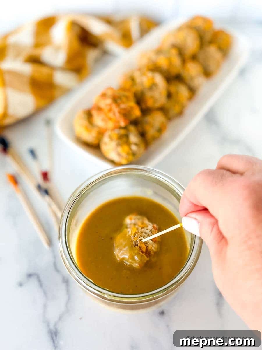 Turkey Sausage Balls Recipe 3 dipping turkey meatballs into a spicy hot mustard sauce in a clear weck jar