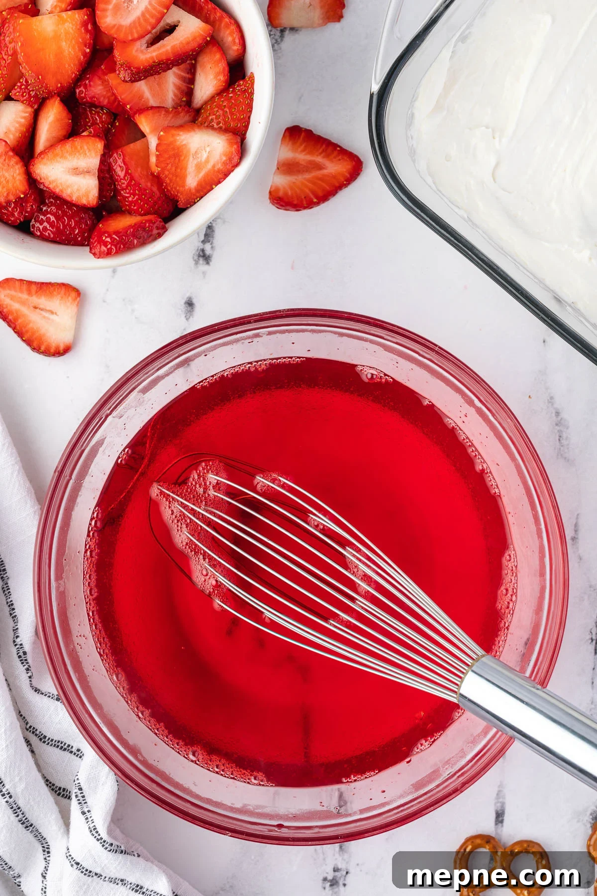 Dissolving strawberry Jell-O in boiling water.