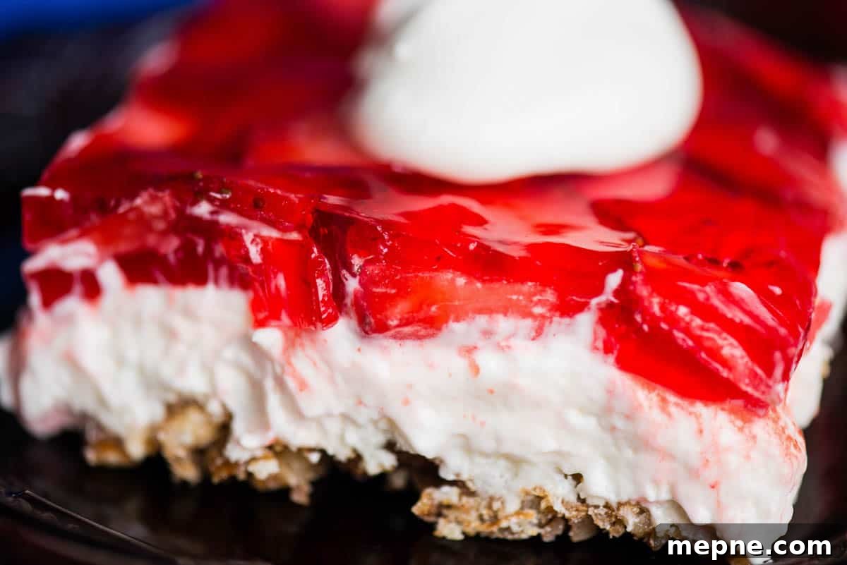 Close up of a slice of homemade strawberry pretzel dessert.