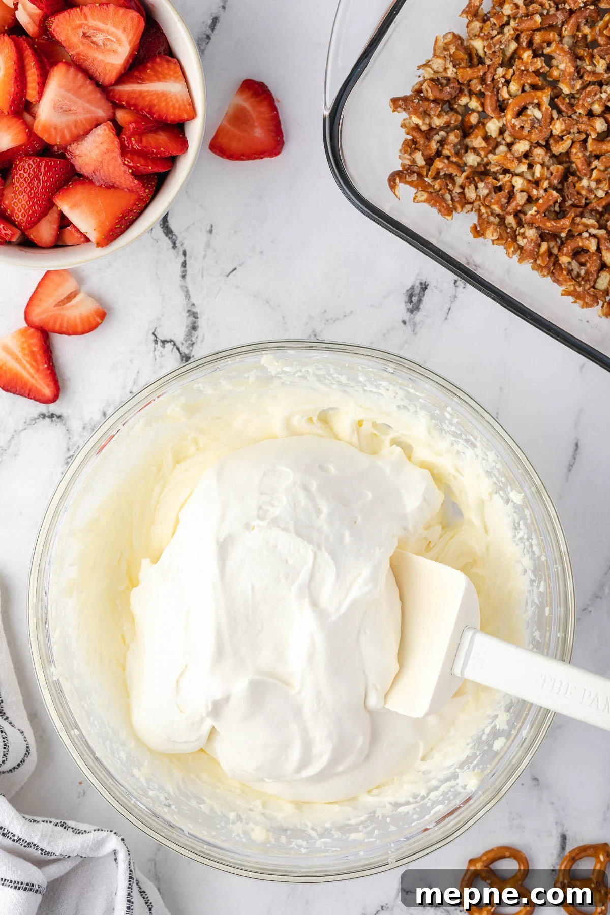 Folding stabilized whipped cream into the cream cheese mixture.