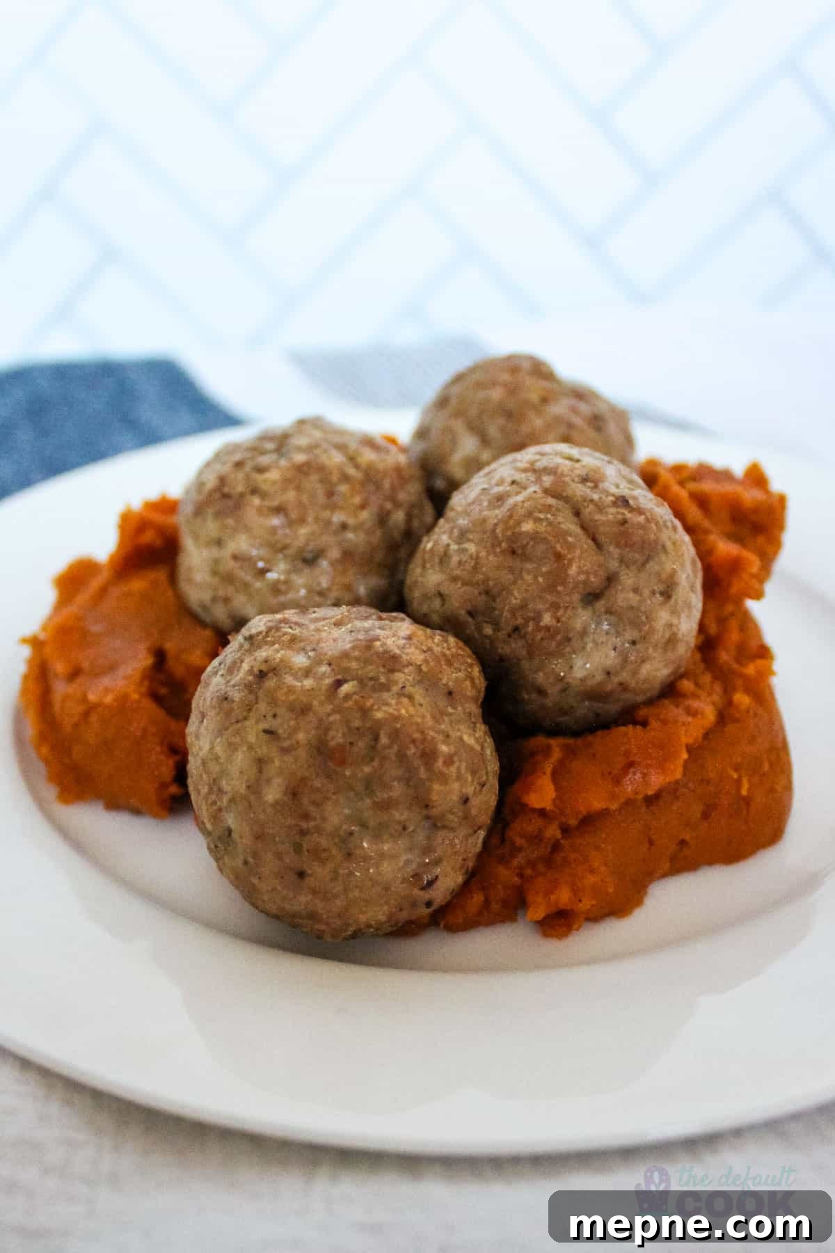 Oven Baked Pork Meatballs with Italian Seasoning 2 4 baked pork meatballs on a bed of mashed sweet potatoes.