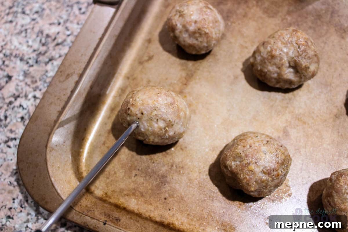 Oven Baked Pork Meatballs with Italian Seasoning 7 A thermometer inserted into a cooked meatball.