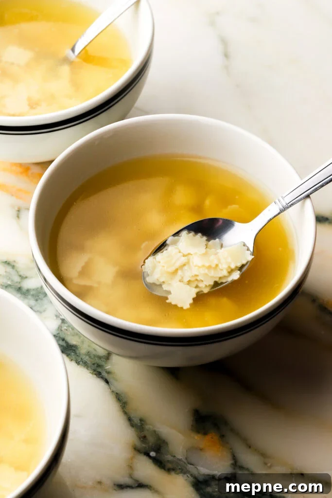 Romanian Chicken Soup (Ciorbă de pui) Recipe 2 three bowls of chicken soup with square noodles on a marble counter top.