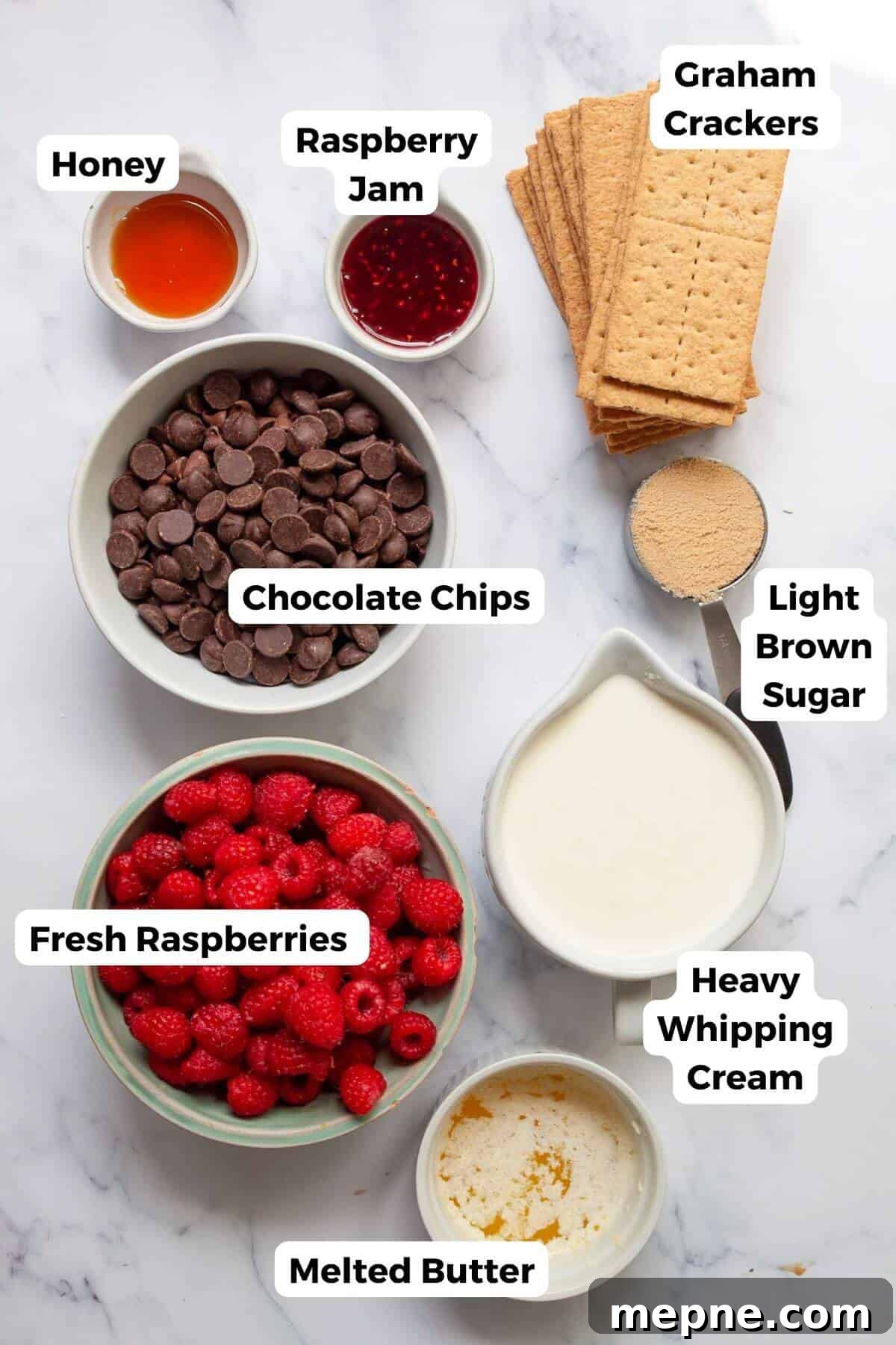 Dark Chocolate Raspberry Tart Recipe 3 Ingredients for chocolate raspberry tart arranged on a marble surface, including graham crackers, chocolate chips, fresh raspberries, heavy cream, butter, honey, raspberry jam, and light brown sugar.
