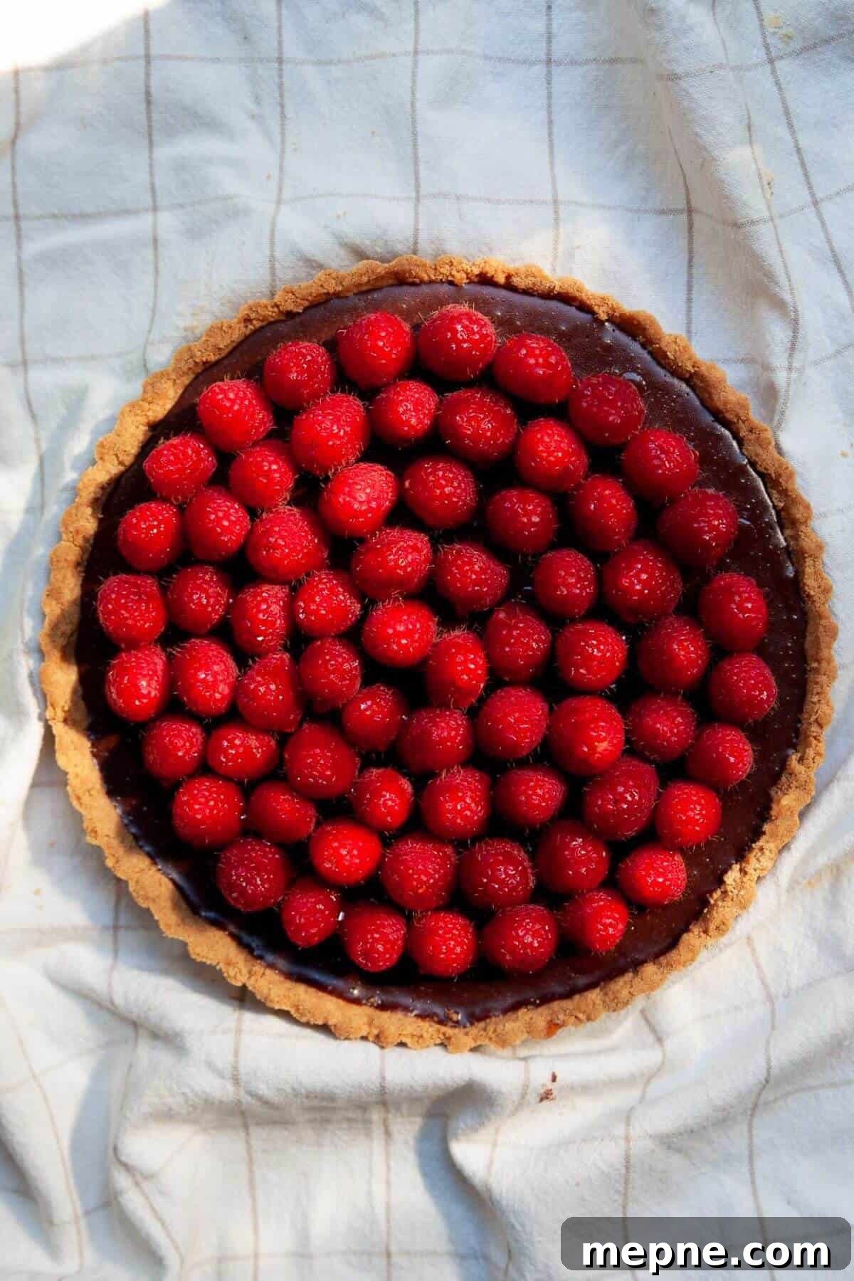 Dark Chocolate Raspberry Tart Recipe 9 Fresh raspberries arranged in concentric circles on top of a set chocolate ganache tart.