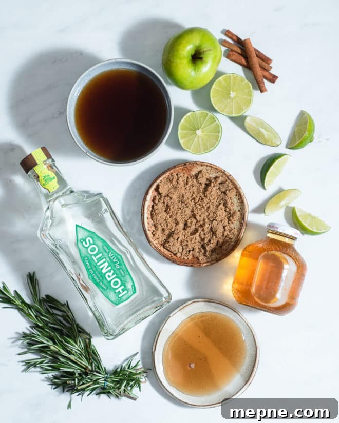 Spiced Apple Cider Margarita Recipe 3 all of the ingredients for apple cider margaritas on a marble surface
