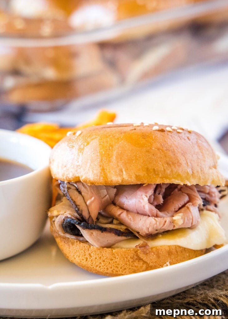 French Dip Sliders Recipe: Mini Beef Sandwiches with Au Jus 2 roast beef slider on a white plate