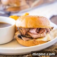 cropped in close up of a french dip slider on a white plate