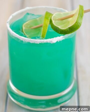 Blue Devil Cocktail served in a highball glass with a lime wedge.