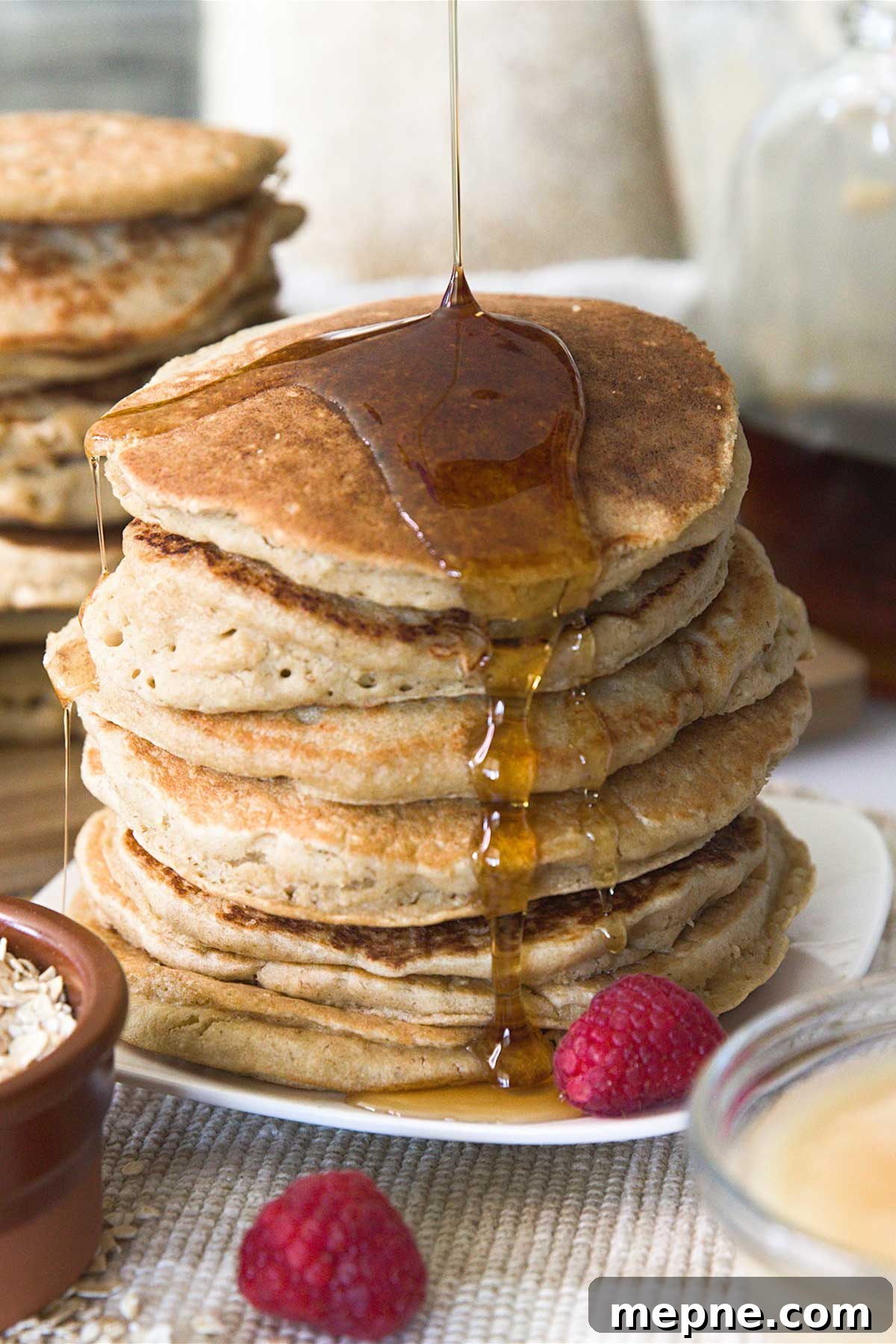 Fluffy Gluten-Free Oat Flour Pancake Recipe 4 Stack of oat flour pancakes on a plate with pouring syrup.