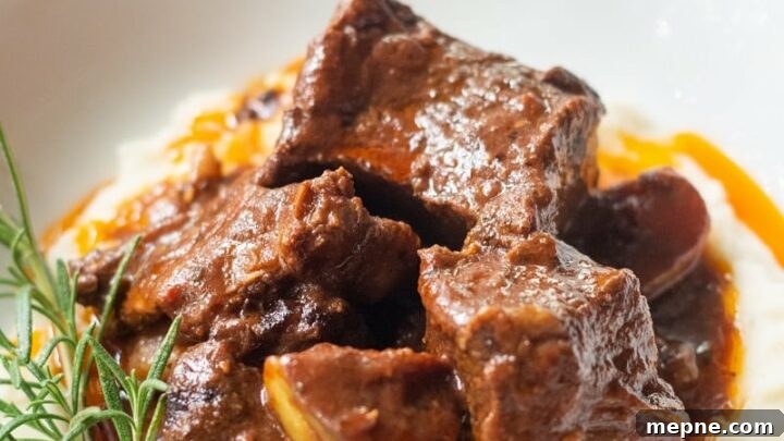 A side view of beef short ribs over mashed potatoes