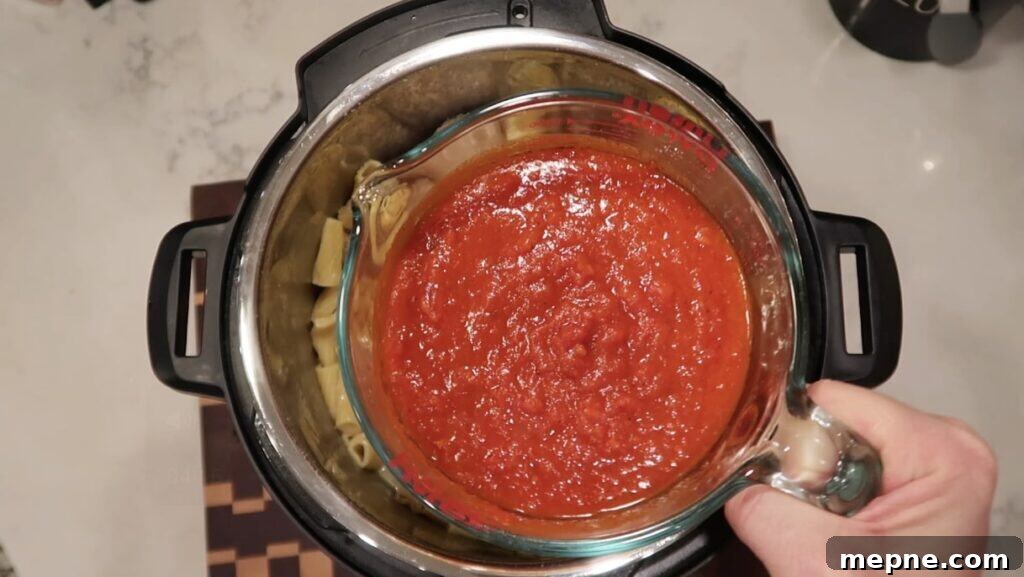 Instant Pot Meatballs with Marinara Pasta 10 Adding marinara sauce to pot
