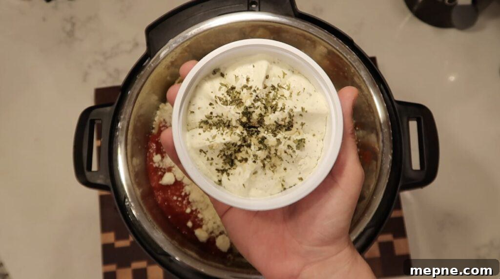 Instant Pot Meatballs with Marinara Pasta 12 Adding herb cheese to pot