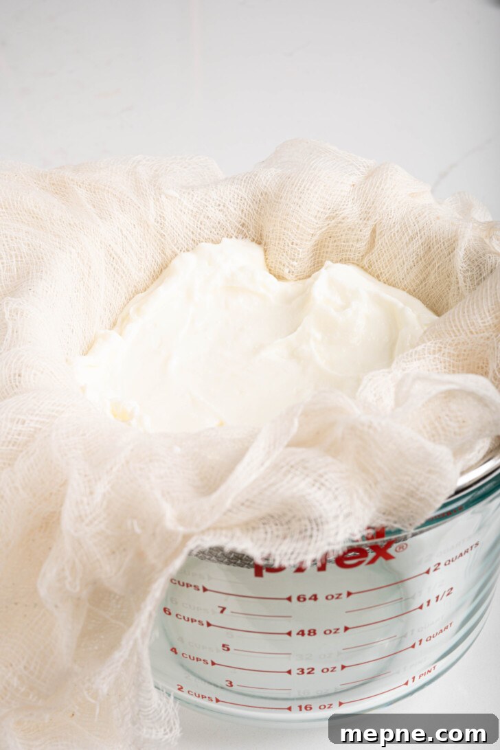2 Ingredient Labneh Strained Yogurt Recipe 5 yogurt in a strainer with cheesecloth