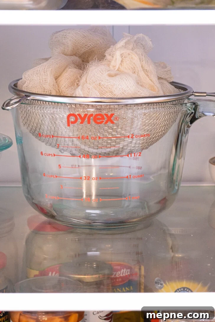 2 Ingredient Labneh Strained Yogurt Recipe 6 labneh in a strainer in the fridge