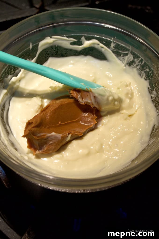 Homemade Cookie Butter White Chocolate Bark Recipe 7 white chocolate and cookie butter in a double boiler on the stove