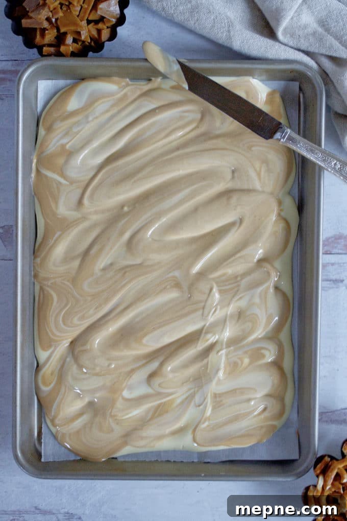 Homemade Cookie Butter White Chocolate Bark Recipe 9 melted white chocolate and cookie butter swirled together on a baking sheet