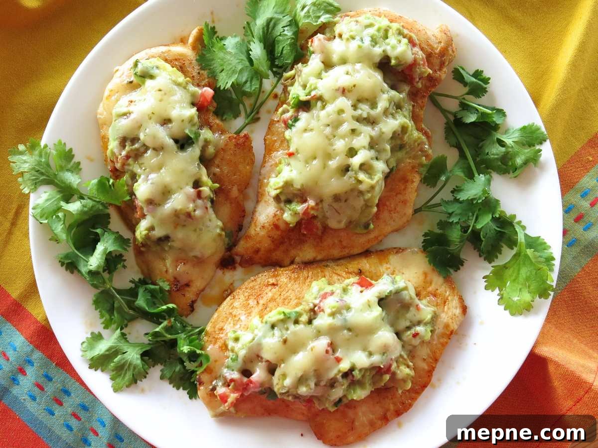 Over 15 Cinco de Mayo Dinner Recipes You'll Make Again 11 Three guacamole chicken breasts on a white plate with cilantro around the edges.