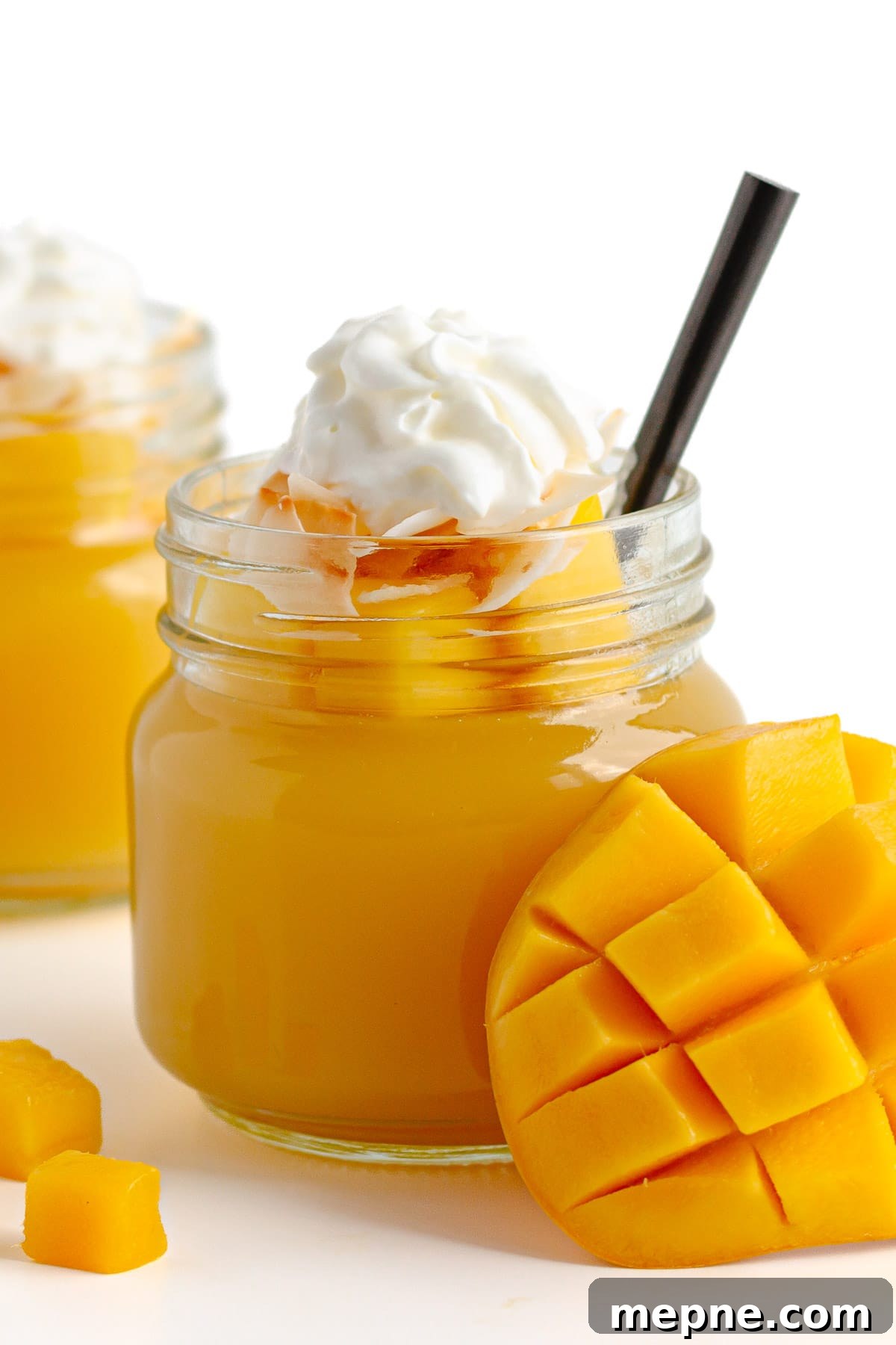 Homemade Mango Jelly Recipe with Fresh Mango 3 Jar of mango jelly topped with diced mango, coconut flakes and whipped cream.