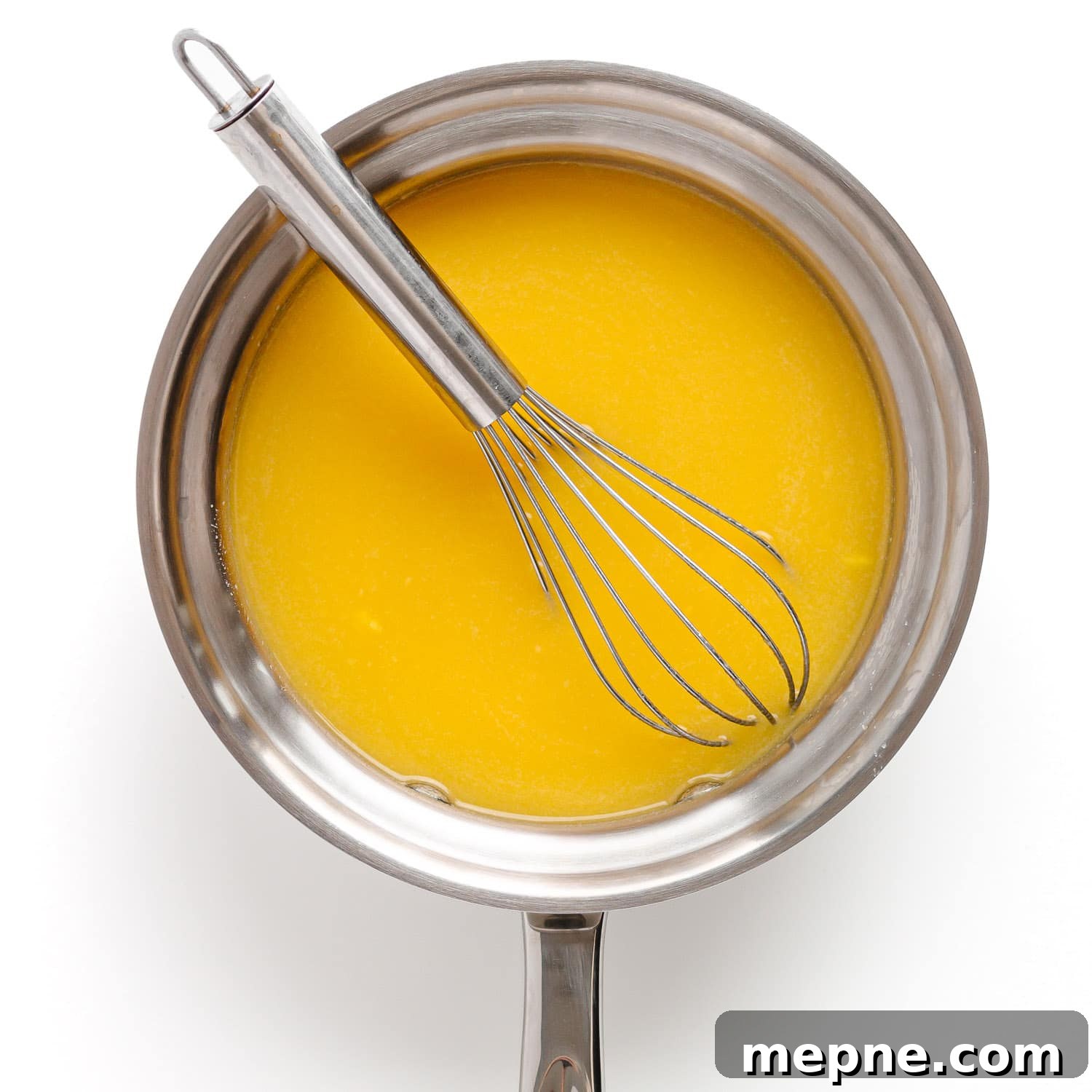 Homemade Mango Jelly Recipe with Fresh Mango 7 Mango puree, water, and honey in a saucepan with a whisk.