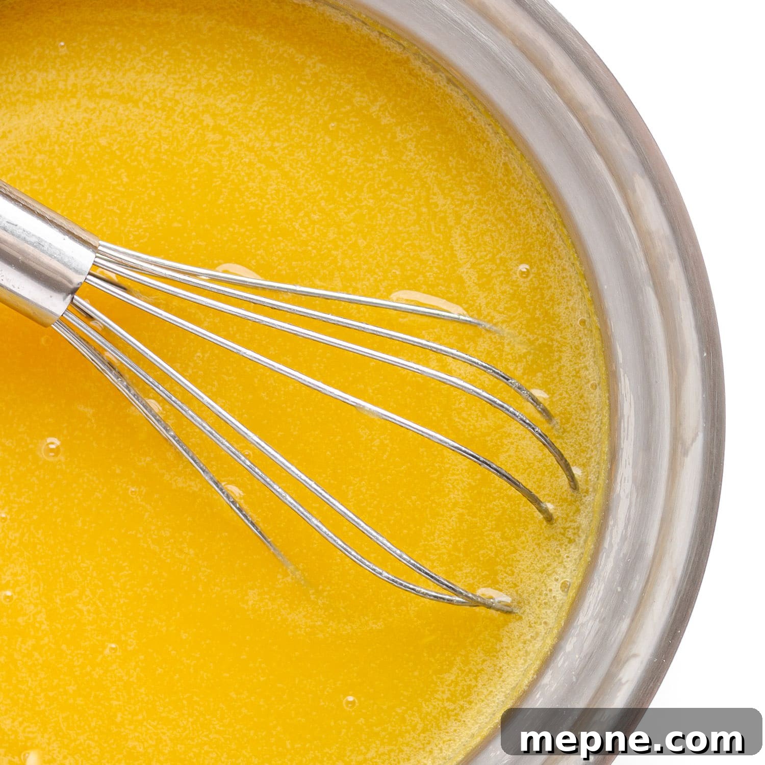 Homemade Mango Jelly Recipe with Fresh Mango 8 Softened gelatin being whisked into mango mixture in a saucepan.
