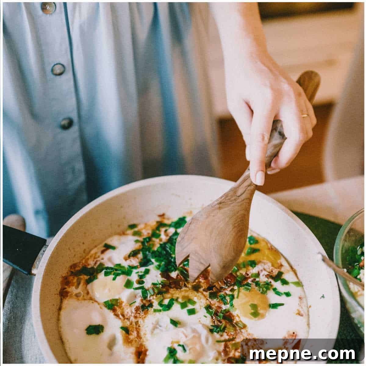 Save Money on Groceries by Cooking at Home 2 Woman cooking in a skillet on the stovetop with a wooden spoon.