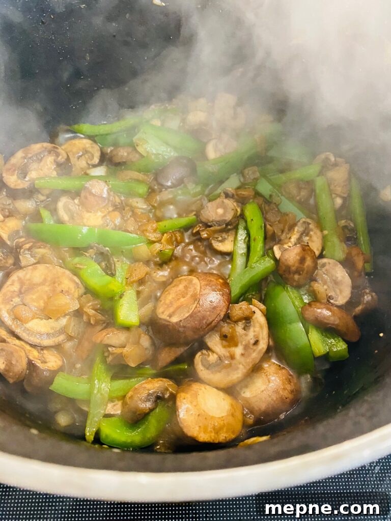 One-Pan Philly Cheesesteak Pasta Recipe 5 cooked mushrooms peppers and onions in a skillet