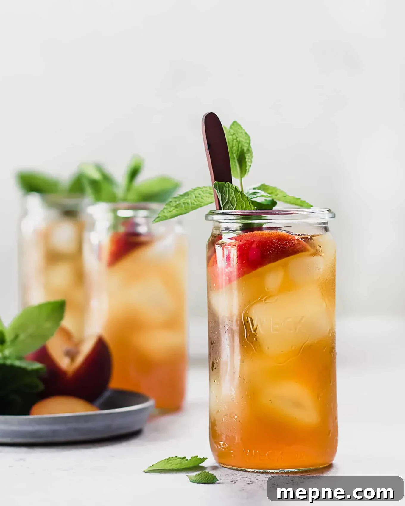 Cold Brew Peach Iced Tea Recipe: Refreshing Summer Drink 2 A cup of cold brew peach iced tea with peaches and mint.