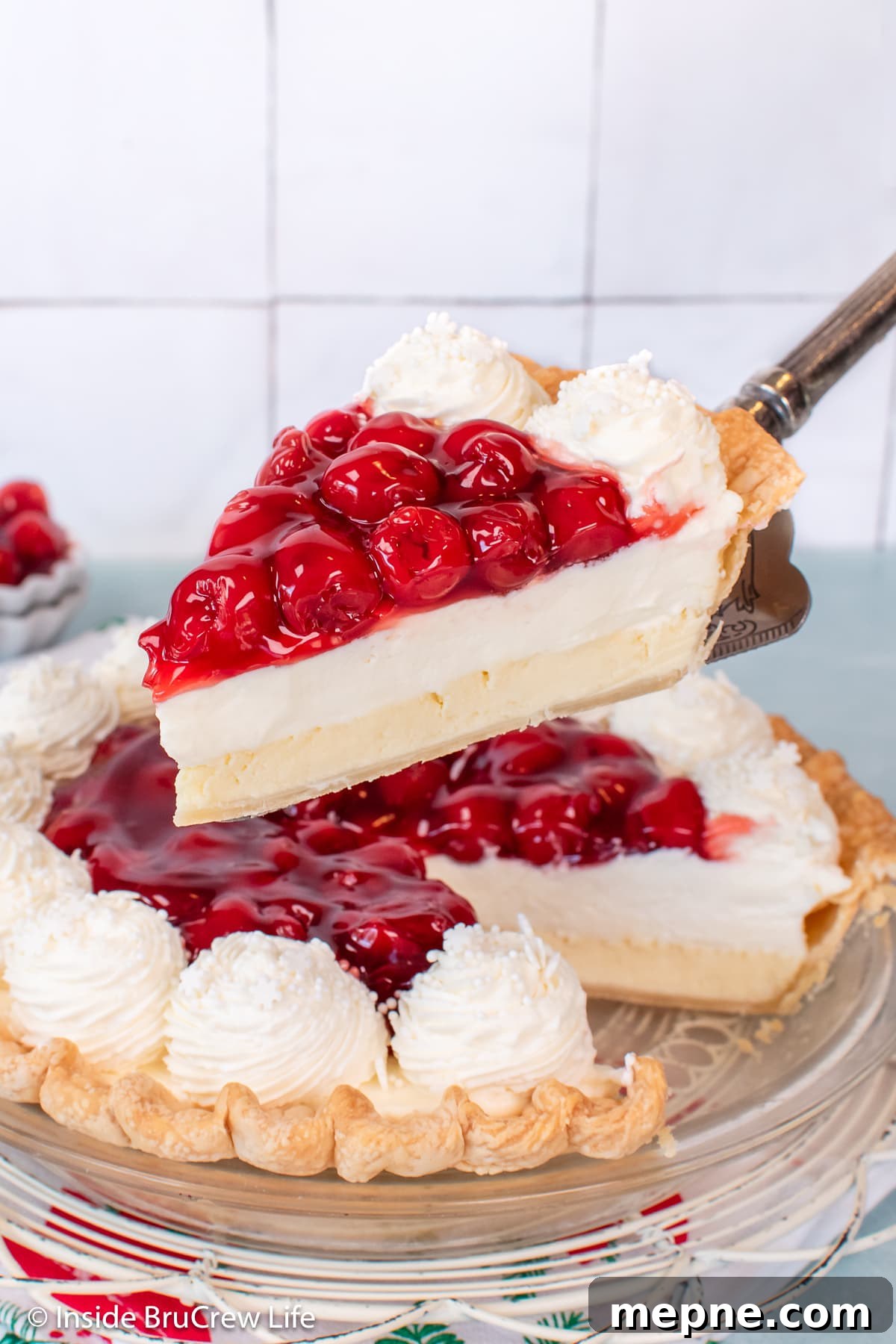 Cherry Pie with Cream Cheese Filling 7 A piece of cream cheese pie with cherries being lifted out of the pan.