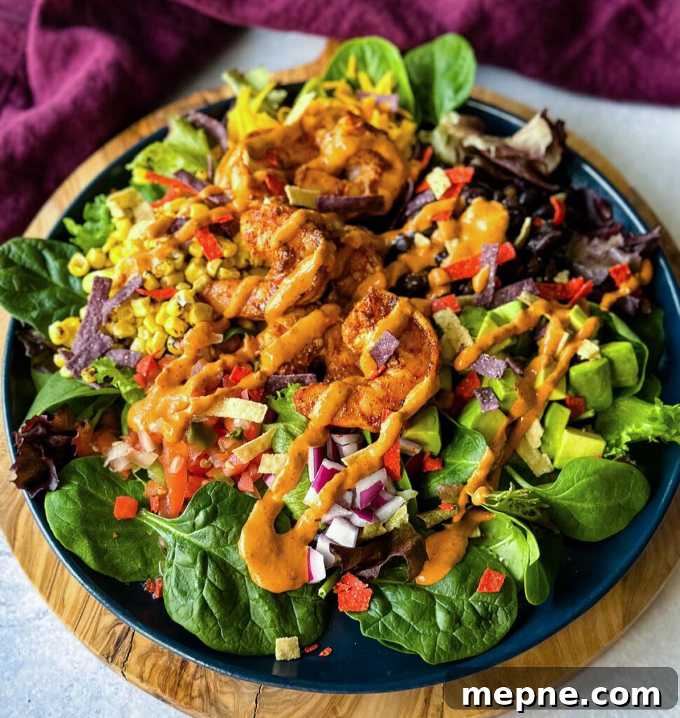 Shrimp Taco Salad with Creamy Lime Dressing 2 shrimp taco salad with avocado, corn, black beans, onions and salsa on a blue plate with Chipotle ranch dressing