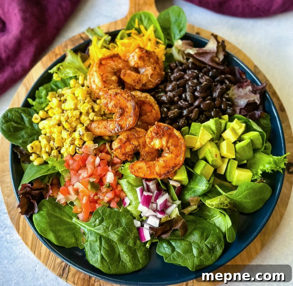 Shrimp Taco Salad with Creamy Lime Dressing 9 shrimp taco salad with avocado, corn, black beans, onions and salsa on a blue plate