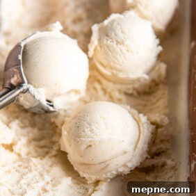 scoops of vanilla ice cream on top of ice cream in container.
