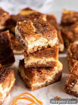 Carrot cake cheesecake bars stacked on each other.