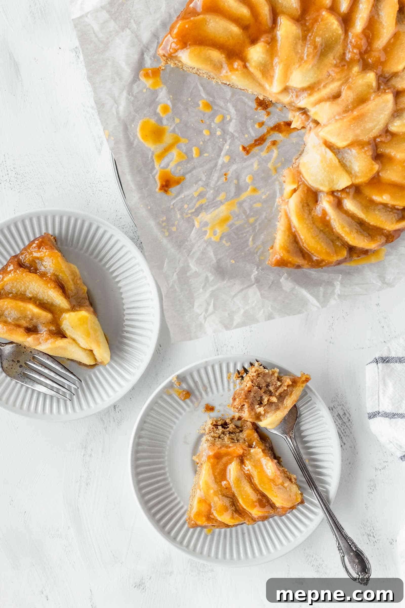 Vegan Apple Cake Recipe with Cinnamon Streusel 4 Two slices of vegan apple cake on small white plates next to the whole cake.
