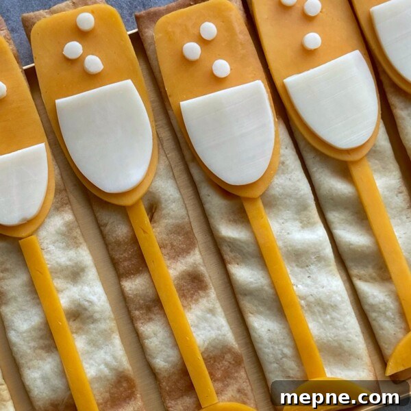 Red White and Blue Caprese Bites for Fourth of July 4 Rectangular crackers topped with cheese and white cheese slices arranged like champagne glasses, with small cheese circles as bubbles—these fun bites are perfect for party food recipes or festive dishes.