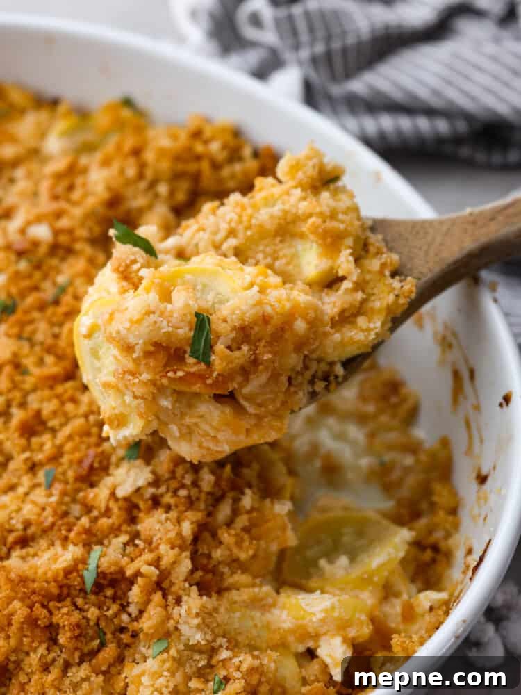 Serving squash casserole. Squash casserole being scooped out with a wooden spoon.