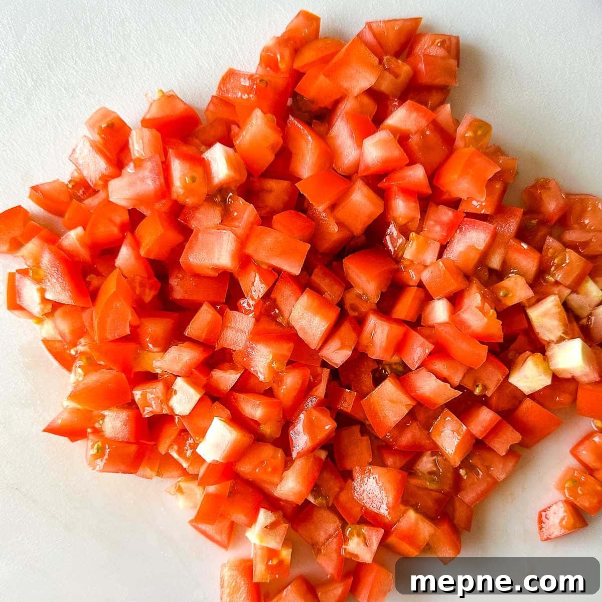 Pineapple Pico de Gallo Recipe: Tropical Salsa 5 Chopped roma tomatoes on a white cutting board.