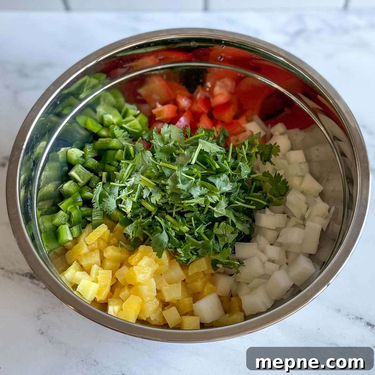 Pineapple Pico de Gallo Recipe: Tropical Salsa 9 The chopped ingredients for pineapple pico de gallo sit in a stainless steel bowl.