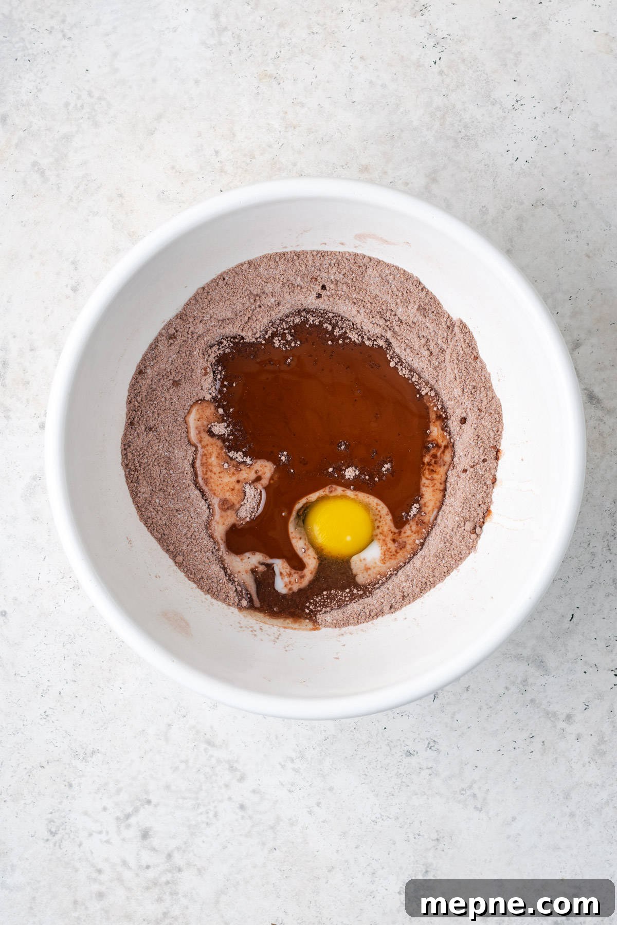 Fudgy Small-Batch Brownies Recipe 5 Wet ingredients added to the dry brownie ingredients in the mixing bowl.