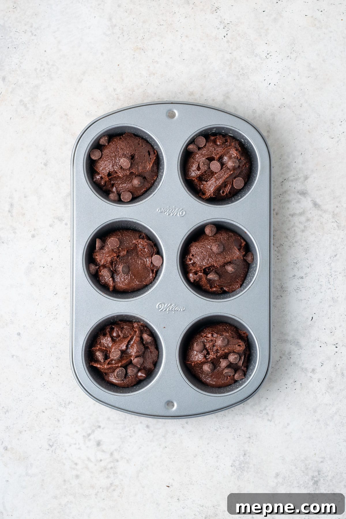 Fudgy Small-Batch Brownies Recipe 7 Brownie batter divided into six muffin cups.