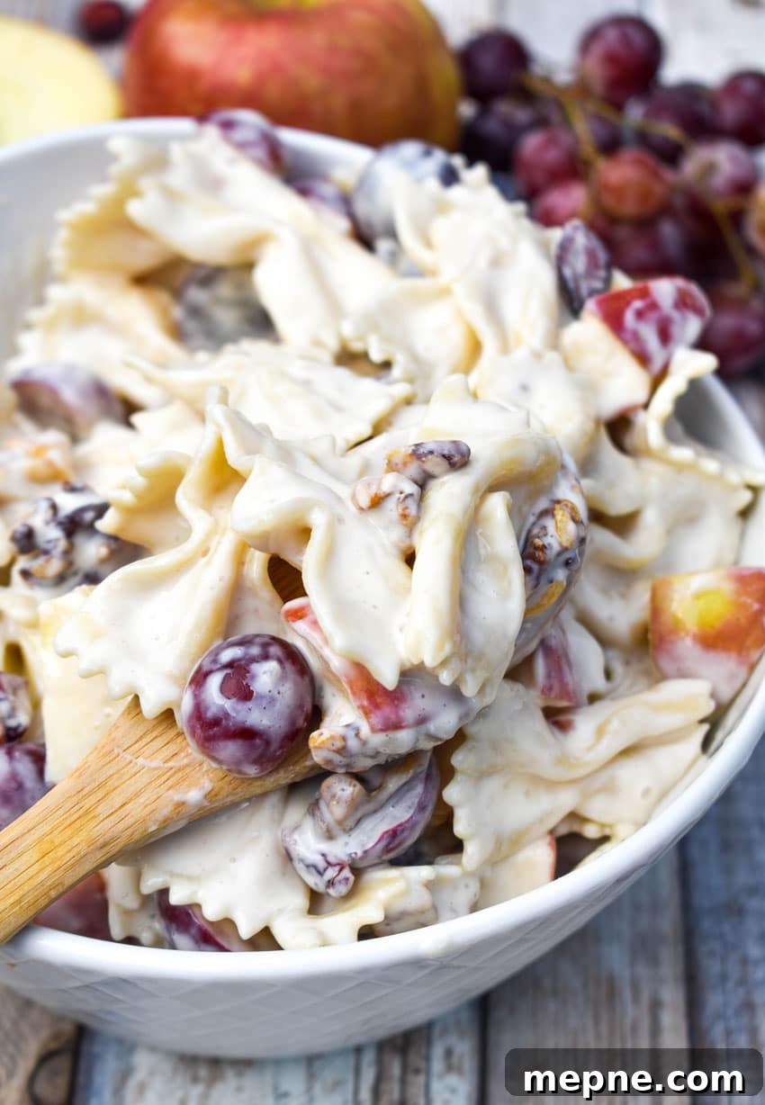 Summer Fruit and Honey Pasta Salad Recipe 6 a wooden bowl in a white bowl filled with a creamy pasta with fruit recipe