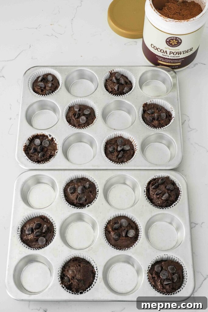 Moist and Fudgy Double Chocolate Muffins Recipe 12 Unbaked double chocolate muffins on a quartz counter.