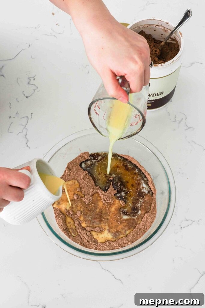 Moist and Fudgy Double Chocolate Muffins Recipe 7 Melted butter and a milk and egg mixture are poured into the dry ingredients for chocolate muffins.