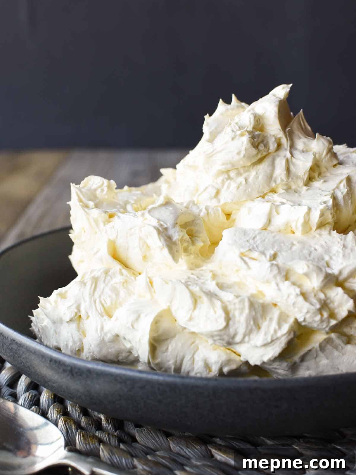 How to Make Italian Meringue Buttercream 2 Italian meringue buttercream in black bowl viewed from the front on.
