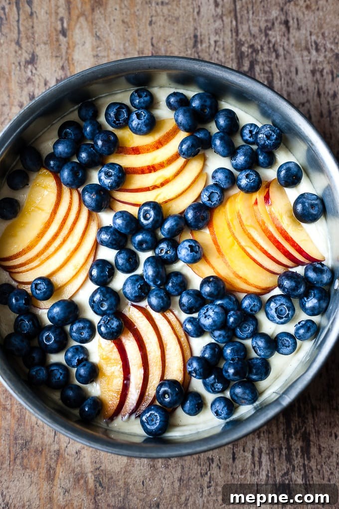 Blueberry coffee cake with nectarines, unbaked in a cake tin.