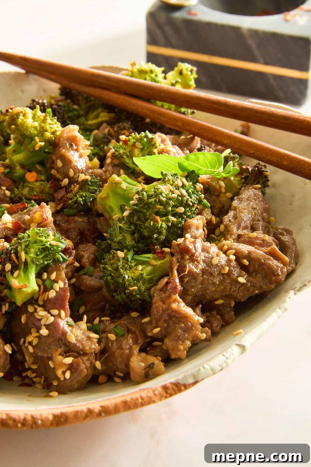 Crispy Air Fryer Beef and Broccoli Recipe 5 Air Fryer Beef and Broccoli in a bowl with chopsticks on top.