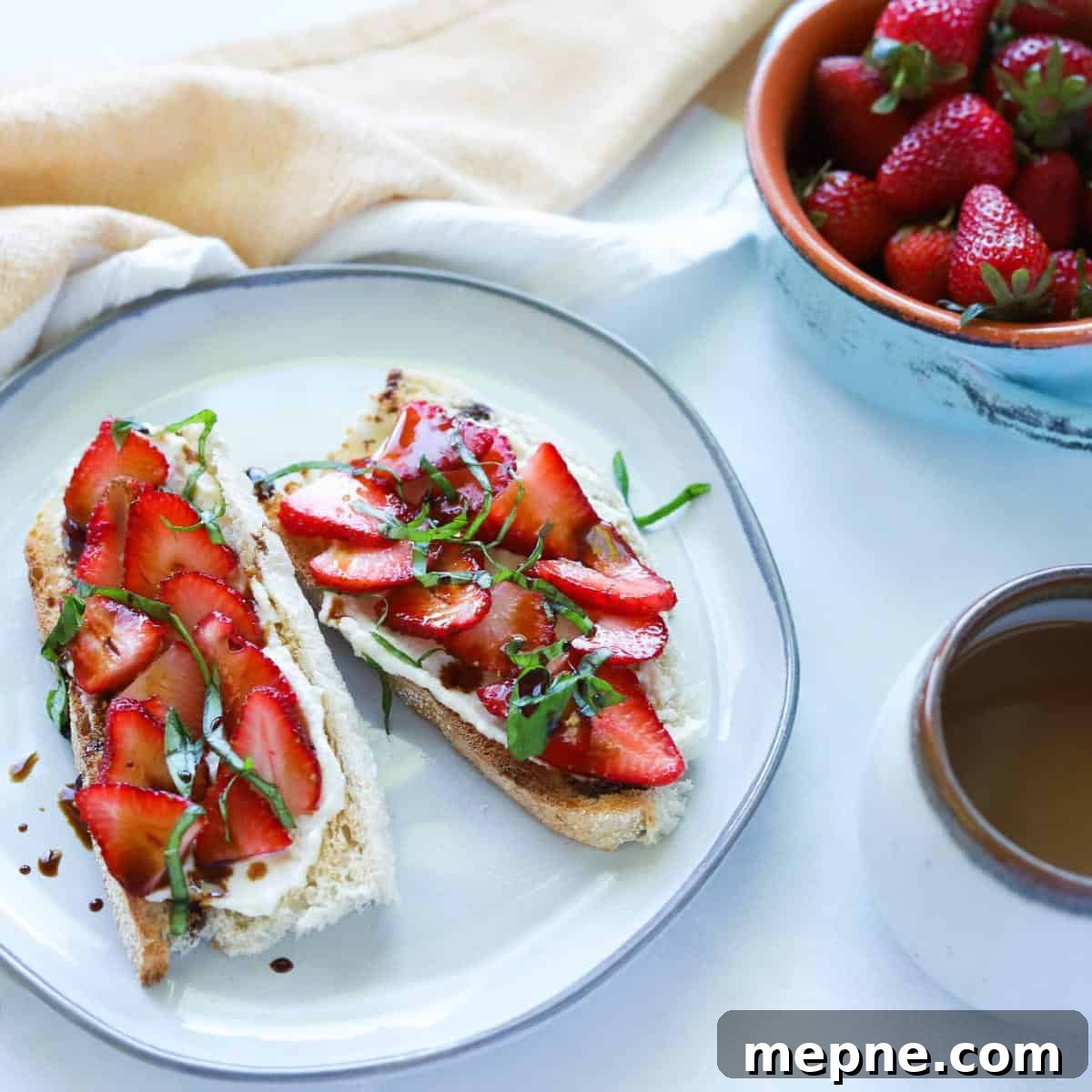 Strawberry Ricotta Toast with Honey Drizzle 8 ricotta strawberry toast with side of strawberries in a bowl and coffee in mug